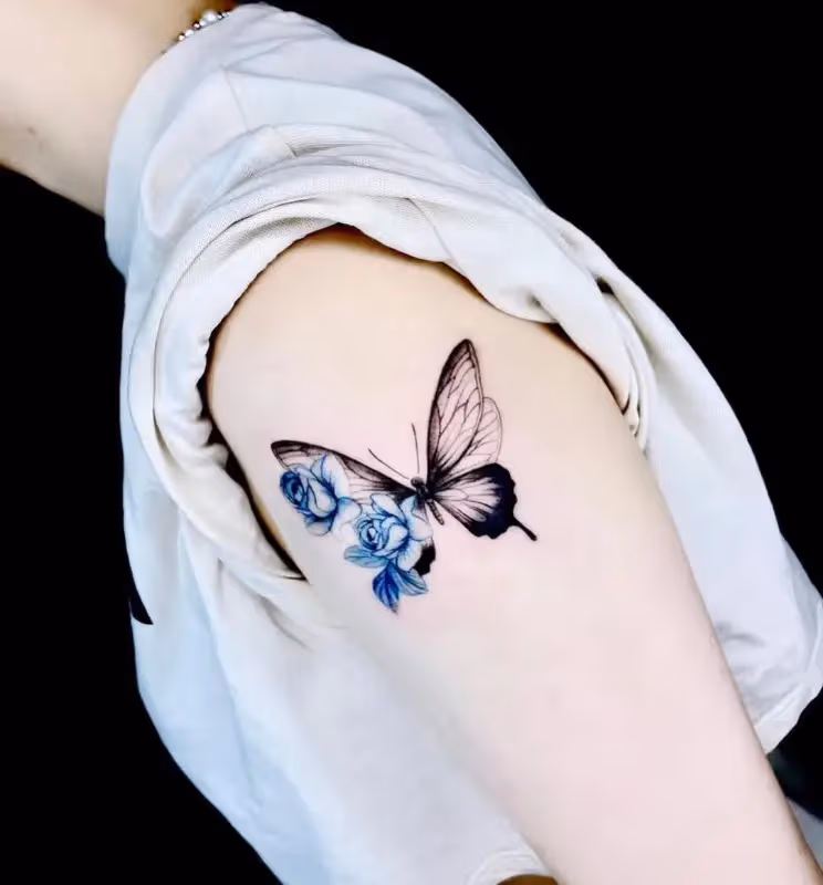 Vivid blue rose and butterfly tattoo