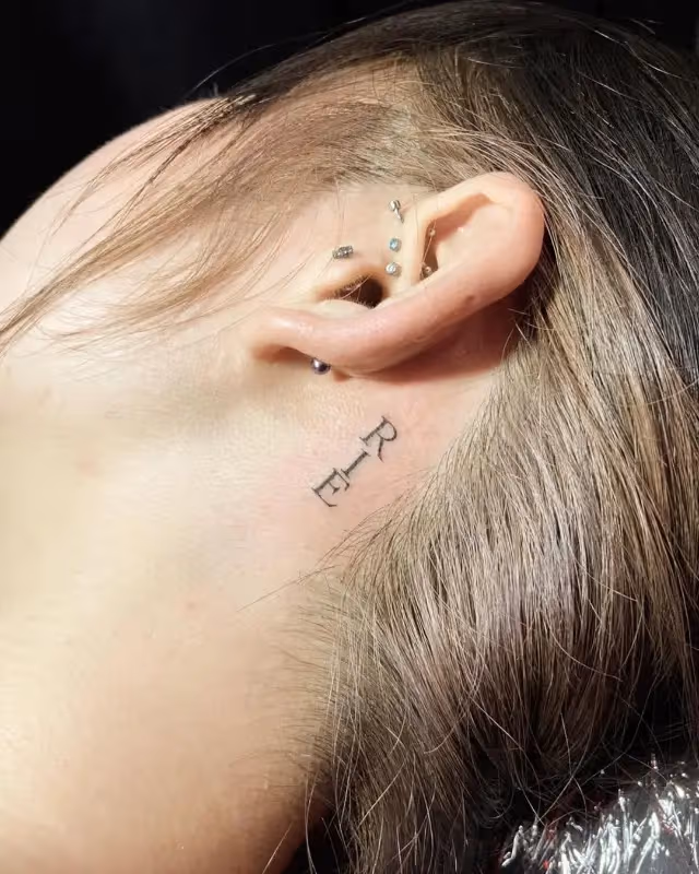 lettering tattoo behind the ear